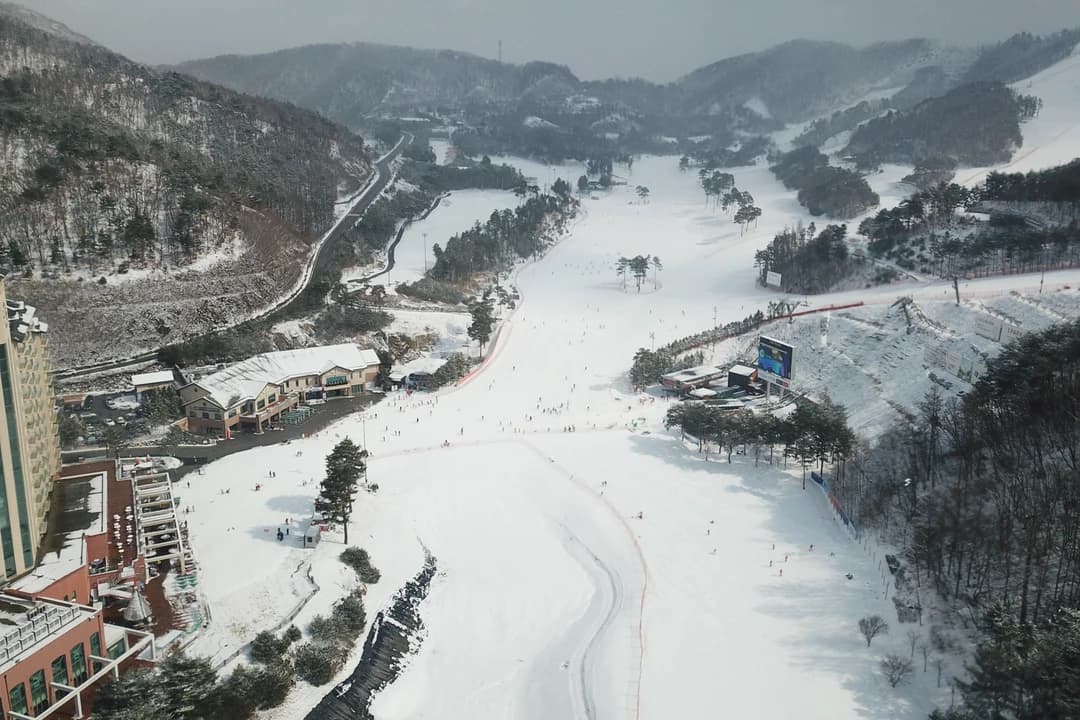 Aerial view of a snowy slope and resort buildings at Oak Valley, Wonju